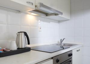 a white kitchen with a sink and a stove at Hotel Bologna in Prague