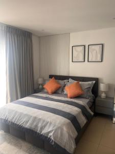 a bedroom with a bed with two orange pillows at Modern 2 bedroom unit in Trofwi