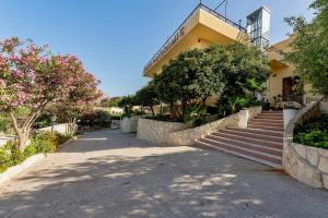 a building with stairs and trees in front of it at HOTIDAY San Vito Lo Capo in San Vito lo Capo