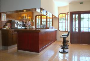 a large kitchen with a bar and a stool at Hotel Carabela 2 in Cullera