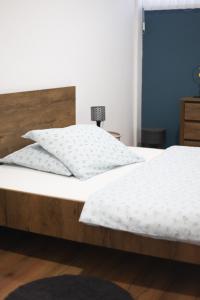 a bed with white sheets and pillows on it at Rooms & Glamping Lana Haus in Ličko Petrovo Selo