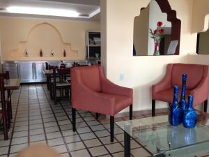 a restaurant with red chairs and a glass table at Hotel Moreno in Coatzacoalcos