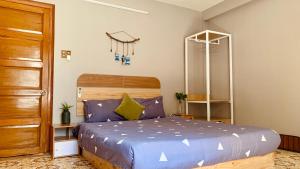 Schlafzimmer mit einem Bett und einer Holztür in der Unterkunft 5B Annie homestay in Nha Trang