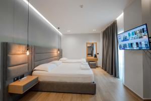 um quarto com uma cama e uma televisão de ecrã plano em Absolute Hotel Ksamil em Ksamil mais 37 fotografias