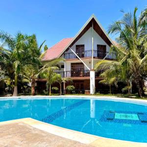 ディアニ・ビーチにあるTropical 2BR Haven in Dianiの家の前にプールがある家