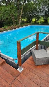 a large blue swimming pool with a wooden deck at The Lions Den - La Loge Guest House in Mantilly