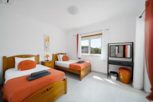 a bedroom with two beds and a window at Porto de Mos 95 by Destination Algarve in Porto de Mós +121 photos