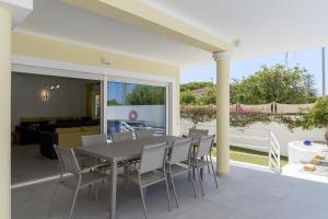 a dining table and chairs on a patio at Porto de Mos 95 by Destination Algarve in Porto de Mós