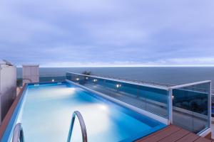 a swimming pool on top of a building with the ocean at Sunset Vibes in Batumi