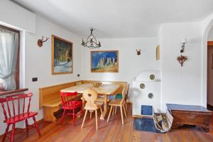 een eetkamer met een tafel en rode stoelen bij Appartamento Serdes Big C2 in San Vito di Cadore