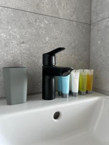a bathroom sink with a faucet and cups on it at Slow Living House in Lozenets