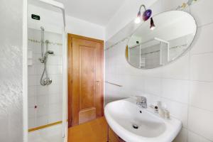 een badkamer met een wastafel en een spiegel bij Appartamento Serdes Big C2 in San Vito di Cadore