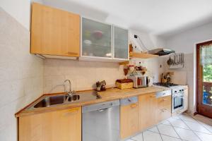 een keuken met houten kasten en een spoelbak bij Appartamento Serdes Big C2 in San Vito di Cadore +16 foto's