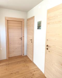 an empty room with a door and wooden floors at Naravna lesena hiša v naravi z lastnim vrtom in Ig