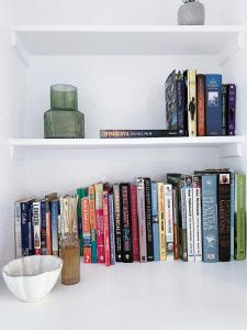 a row of books on a shelf with a bowl at The Willow Nook in Pateley Bridge