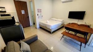 a living room with a couch and a bed and a table at THE SHORE KK CITY VIEW S15 By BC 亚比城市景观 in Kota Kinabalu +4 photos