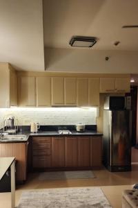 a kitchen with wooden cabinets and a stainless steel refrigerator at The Venice Luxury Residences Condominium 28B Bellini, McKinley Hill, Taguig City, Philippines in Manila