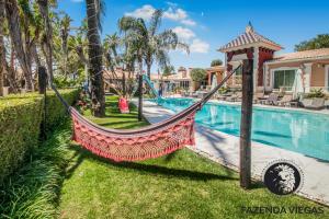 a hammock in a yard next to a swimming pool at Fazenda Viegas in Lagos
