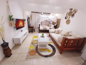 a living room with a couch and a table at Diani Studio with 3 Pools & Balcony in Diani Beach