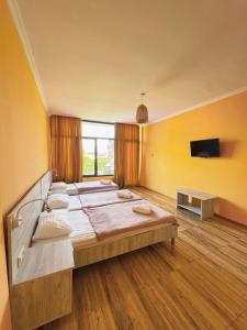 a large bedroom with a large bed and a flat screen tv at Sunny days Kobuleti in Kobuleti