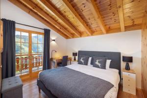RiddesChalet Belle Vue – Alpine Charm with a View to Remember的一间卧室设有一张大床和木制天花板