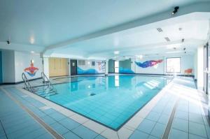 a large swimming pool in a building at Aurora on the Dunes- Cozy Coastal Retreat with Scenic Views in Lossiemouth