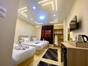 a hotel room with two beds and a television at Isis Pyramids View Inn in Cairo