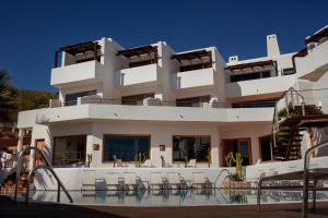 un gran edificio blanco con una piscina frente a él en Boutique Hotel El Tio Kiko en Agua Amarga