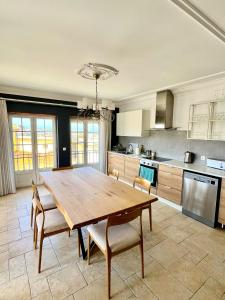 a large kitchen with a wooden table and chairs at Alojamento Real in São Pedro da Cadeira +17 photos