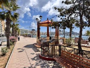 a park with a gazebo on a sidewalk at Charming flat off the sea front in Il-Gżira