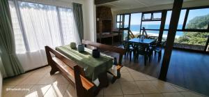 a dining room with a table and chairs and a view of the ocean at Beachwood Cottage in Margate