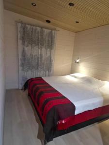 Un dormitorio con una cama con una manta roja y blanca. en Cahkal Villa, en Kilpisjärvi