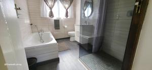 a bathroom with a tub and a sink and a toilet at Beachwood Cottage in Margate +20 photos