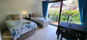 a bedroom with two beds and a balcony at Beachwood Cottage in Margate