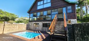 a house with a swimming pool in front of it at Beachwood Cottage in Margate