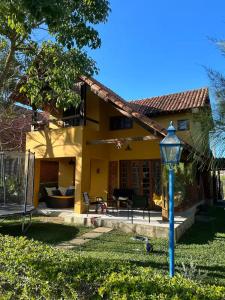 ein Haus mit einer blauen Straßenlaterne im Hof in der Unterkunft Condomínio Village do Araripe - Casa Brisa da Serra in Gravatá