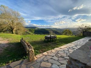 a stone walkway with a bench in a field at Cabaña Pasiega Lucas in Bustantegua