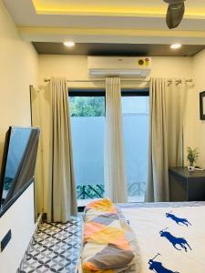 a bedroom with a bed and a large window at Hostique Blossom, Private Studio for Staycation in Indore +2 photos