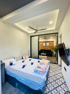 a bedroom with a bed and a flat screen tv at Hostique Blossom, Private Studio for Staycation in Indore