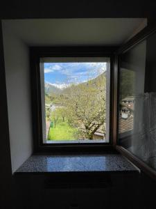 a window in a room with a view of a tree at Appartamento Bonomelli in Enguiso