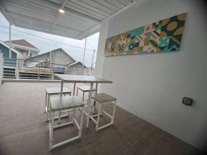 a table and two chairs and a painting on a wall at Smooth Villas in Wonosobo