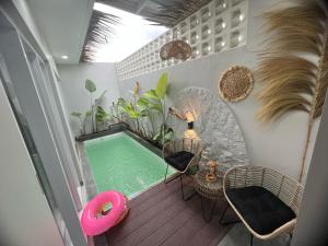 a small swimming pool in a room with chairs at Smooth Villas in Wonosobo