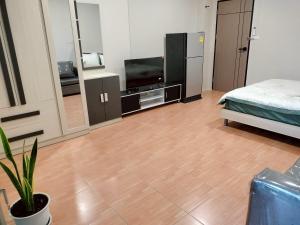 ein Wohnzimmer mit einem Bett und einem Fernseher in der Unterkunft สบาย สบาย เพลส อพาร์ทเม้นท์ in Ban Han Tra Fang Nua + 9 Fotos