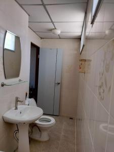 ein Badezimmer mit Toilette, Waschbecken und Spiegel in der Unterkunft สบาย สบาย เพลส อพาร์ทเม้นท์ in Ban Han Tra Fang Nua