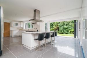 a kitchen with a counter and stools in it at The Luxury Country Home in Aughton