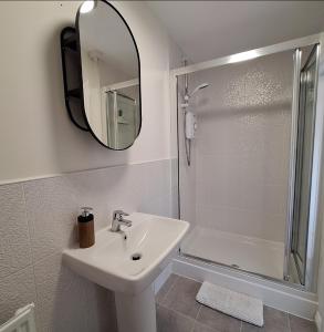 a bathroom with a sink and a shower and a mirror at 3 bed house Stratford-upon-Avon, River, Theatre and Restaurants in Stratford-upon-Avon