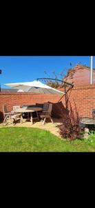 a picnic table with an umbrella next to a brick wall at 3 bed house Stratford-upon-Avon, River, Theatre and Restaurants in Stratford-upon-Avon