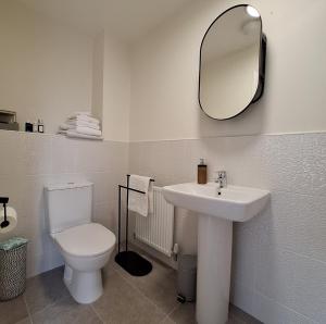 a bathroom with a toilet and a sink and a mirror at 3 bed house Stratford-upon-Avon, River, Theatre and Restaurants in Stratford-upon-Avon +16 photos