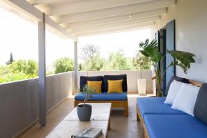 a living room with blue couches on a balcony at Villa Primarosa in Metaxáta