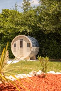 a round building with a roof on the grass at Burbujas de amor - gîte avec spa et sauna privatifs in Loubès-Bernac